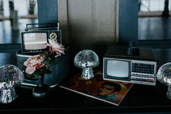 close-up of cocktail hour display with mushroom-shaped disco balls and small vintage TVs