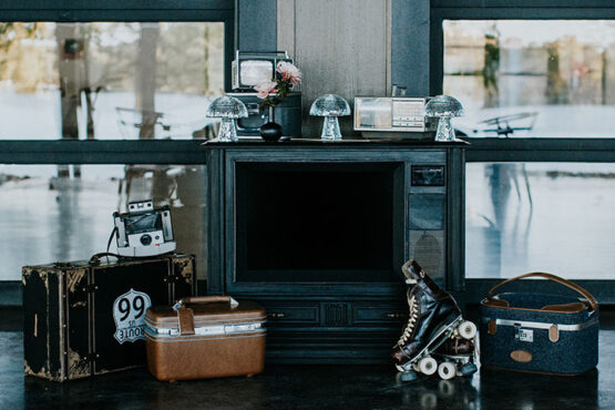 retro decor on patio featuring vintage luggage, roller skates, mushroom-shaped disco balls, and an old box TV frame