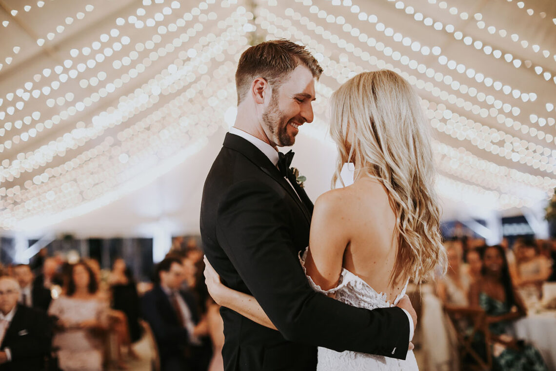 Brielle and alec's first dance under string lighting in the sunset terrace