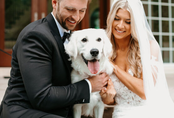 Bride and groom pose for photos with their cream golden retriever