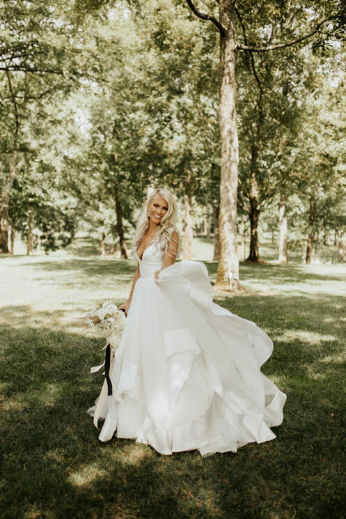 Bride smiling on mansion's front lawn