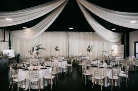 Romantic Wedding Reception Setup in the Lakeview Event Cente with white drapery and silver chairsr