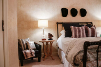 CDM Mansion_Garth-Bedroom_5 Garth Brooks themed bedroom inside the Mansion with black iron bedframe and cowboy hats hung on the wall