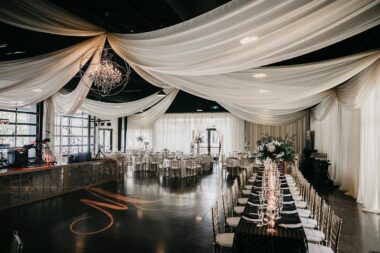 Wedding reception inside Lakeview Event Center with dramatic drapery and monogrammed dance floor