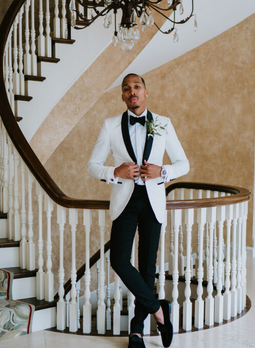 Darin poses inside the Cherokee Dock mansion against the grand staircase railing