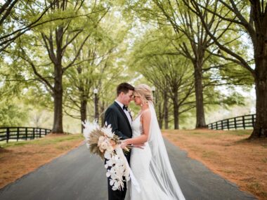 Bride and Groom pose in Cherokee Dock's long driveway