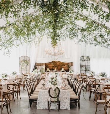 Wedding Reception setup on Sunset Terrace with greenery-covered ceiling and elegant white decor