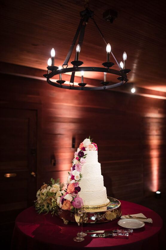 4 tier wedding cake with bold pink florals in the carriage house stables