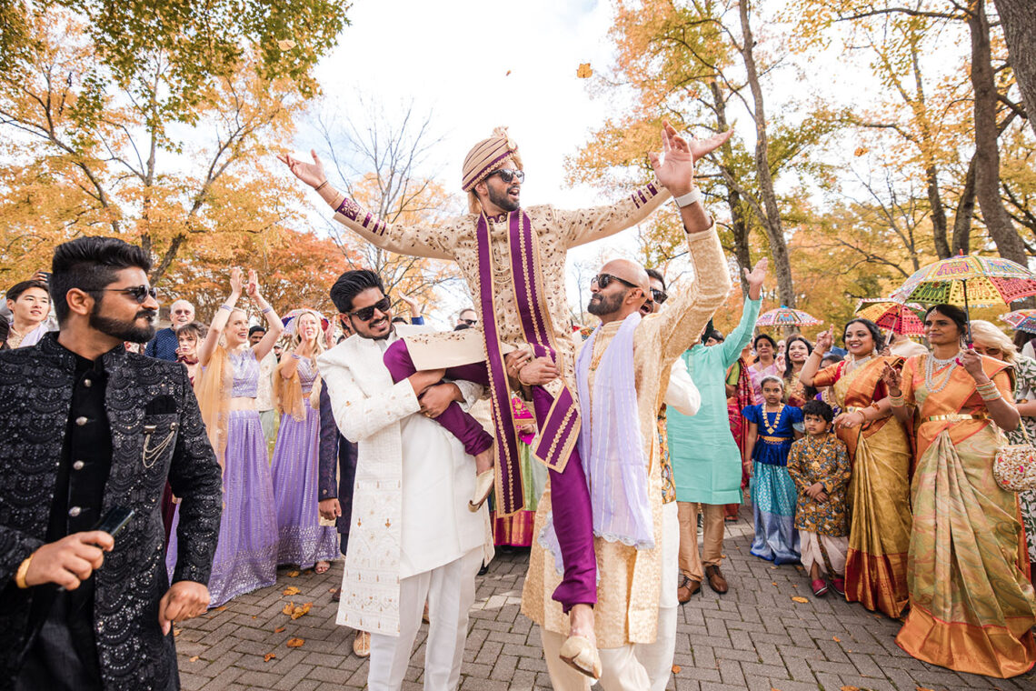 Indian groom celebrates while being carried on the shoulder of his friends