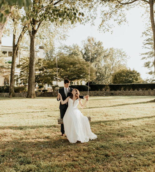 Bride and groom on Lakeside Lawn swing airy bright photography