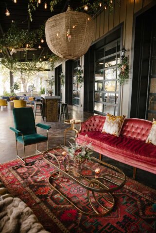 Vintage velvet furniture setup on the Lakeview Event Center patio with oriental rug and brass coffee table