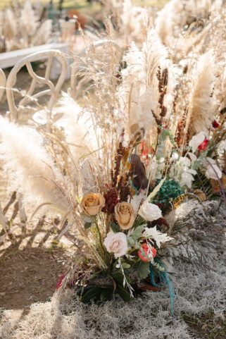 Boho Wedding Ceremony Aisle Marker with earth-colored florals and dried pampas grass