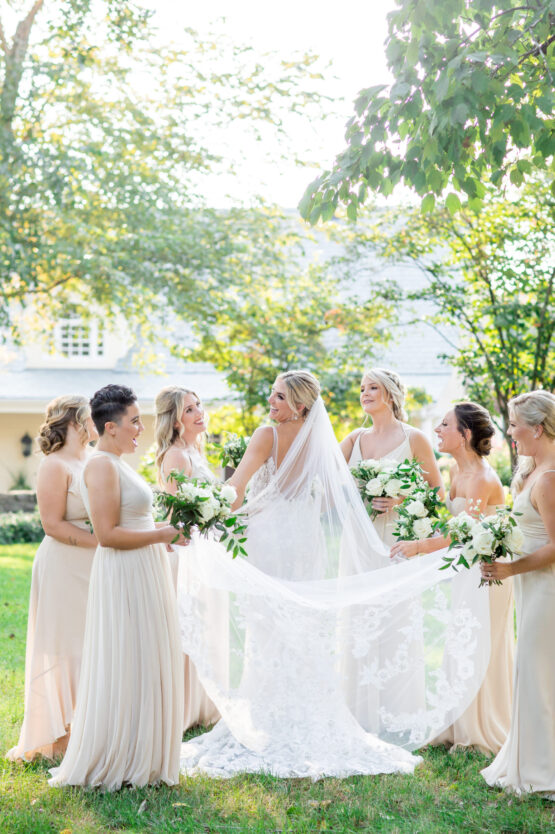 Bride in Lace Dress with Long Lace Veil and Classic White Bouquet | Champagne Colored Bridesmaids Dresses | Bridal Party Photo Inspiration | Airy Wedding Style