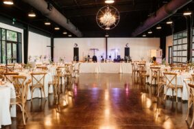 Wedding reception setup with stage for band and white tables inside Lakeview Event Center