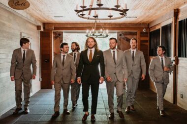 Groom and groomsmen walking through Carriage House Stables