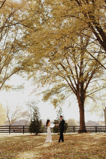 jessica and ben holding hands under the fall foiliage