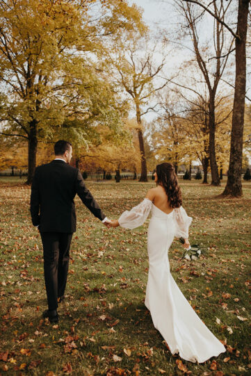 jessica and ben holding hands under the fall foiliage