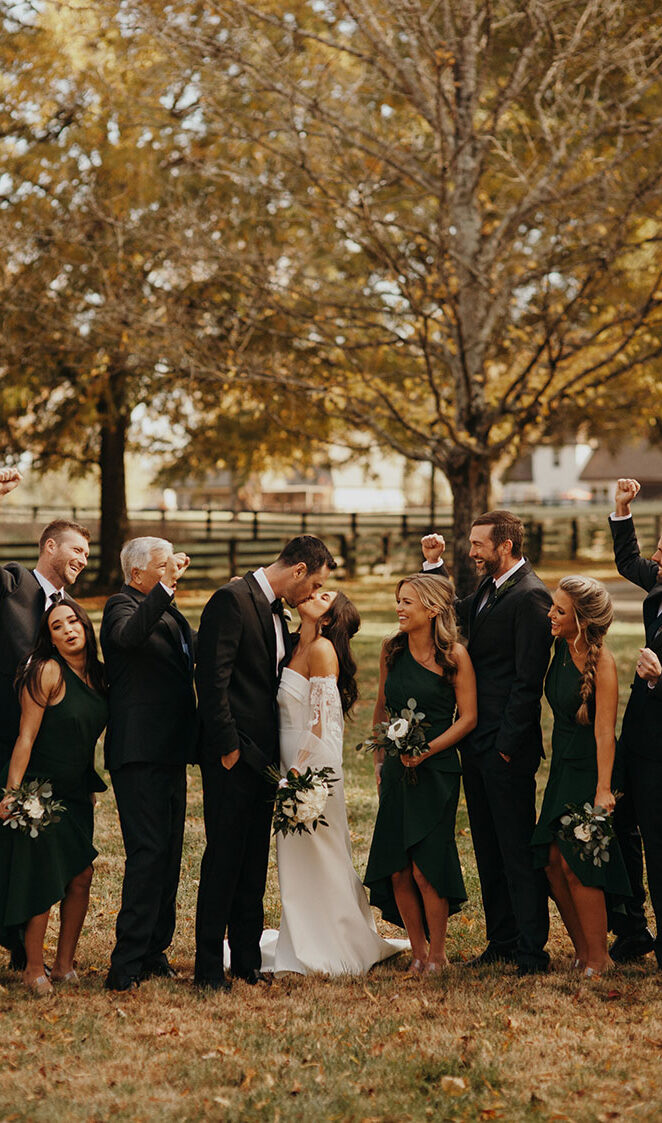 jessica and ben pose with their wedding party under the willow oak canopy