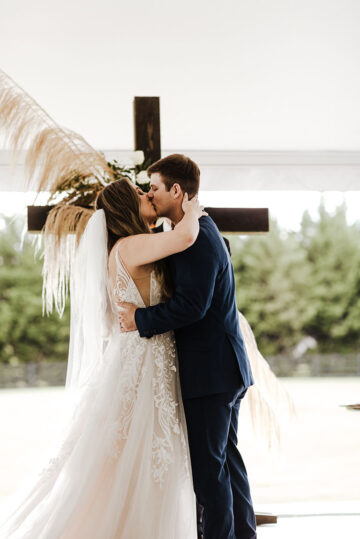 Dark Wooden Ceremony Cross with Rust Autumn Leaves White Roses and Greenery | Boho Fall Wedding Inspiration | The Estate at Cherokee Dock