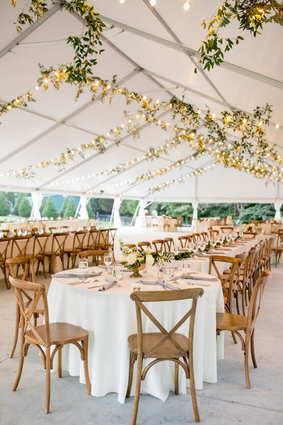 Wedding reception setup on Sunset Terrace with wooden chairs, white linens, and greenery decor