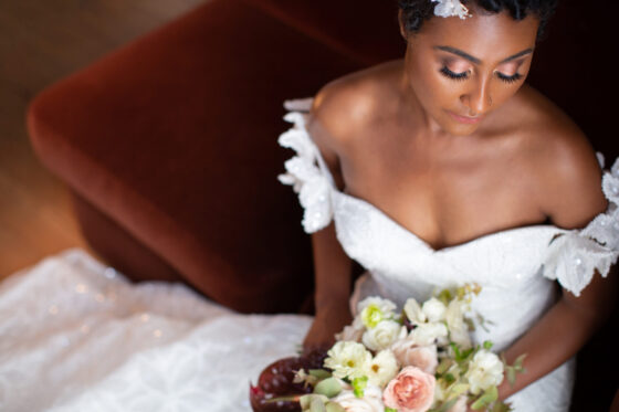 Bride poses on bench inside mansion