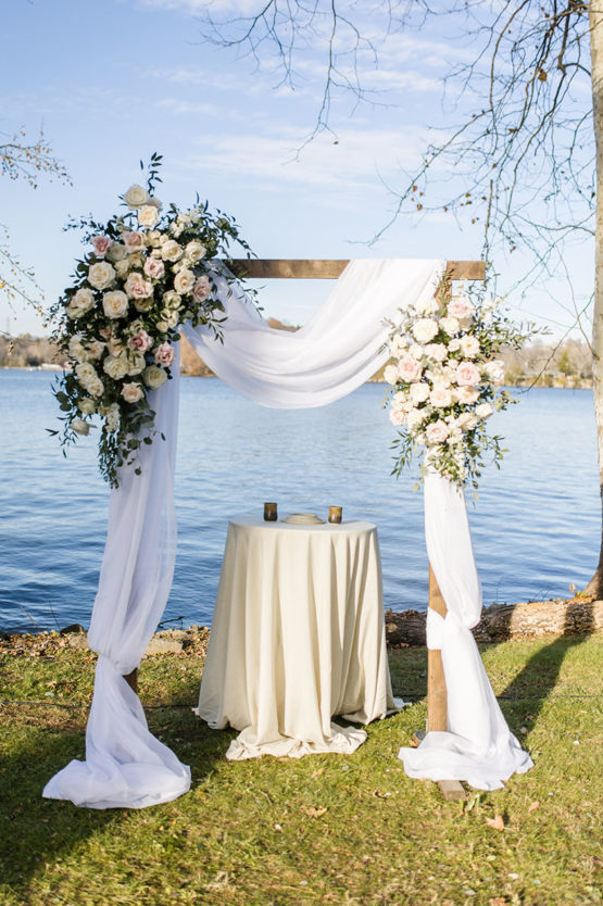 wedding ceremony arch on the lakeside lawn