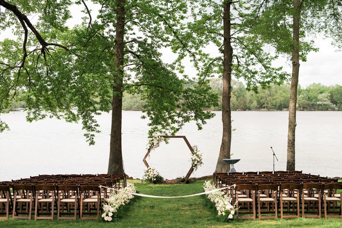lakeside ceremony with geometric wooden arch
