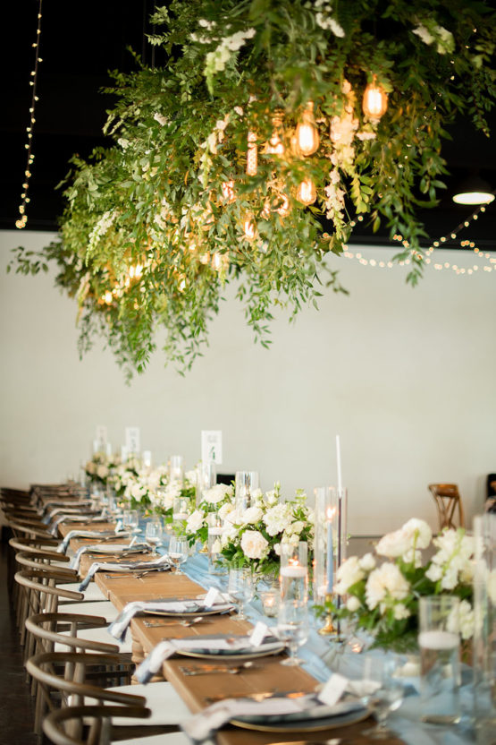 Hanging Greenery Installation with Edison Bulb Lighting with White Rose Centerpieces and Floor-to-Ceiling Drapery | Lakeview Event Center at the Estate at Cherokee Dock