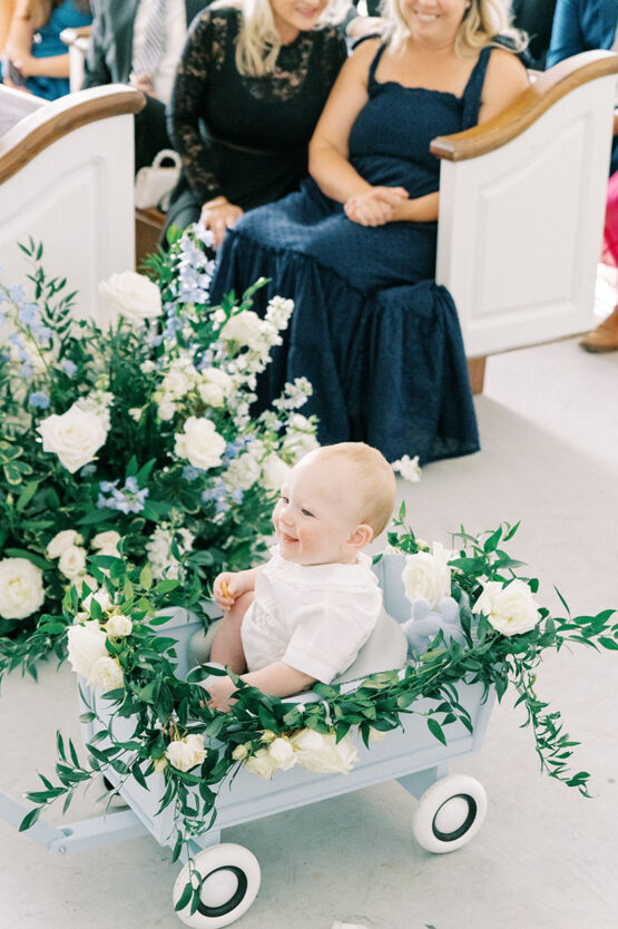 Baby ring bear in blue wagon pulled down aisle