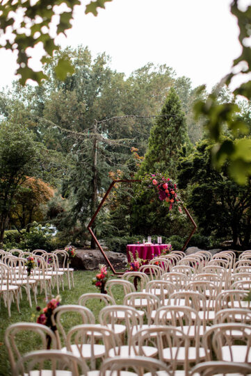 Wedding ceremony setup with white chairs and hexagonal ceremony arch