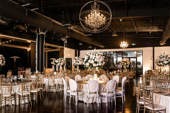 Wedding reception setup inside Lakeview Event Center with tall large floral arrangements