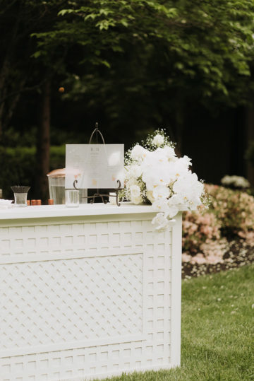 white bar with acrylic signage and florals