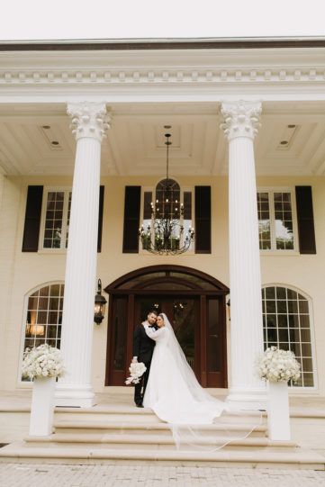bride and groom on the mansion stair case
