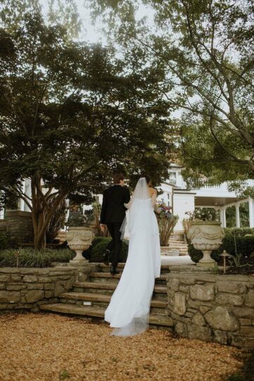 The bride and groom walking toward the pool from the Lakeside Lawn