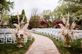 Large Boho floral arrangements at start of wedding ceremony aisle