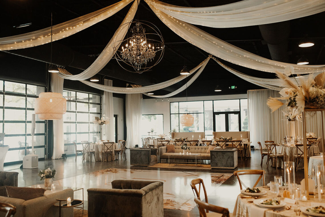 indoor wedding reception with floor to ceiling draping around the entire space along with lounge seating set in the middle