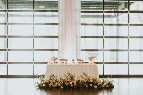 Sweetheart table with romantic floral arrangements at reception inside Lakeview Event Center